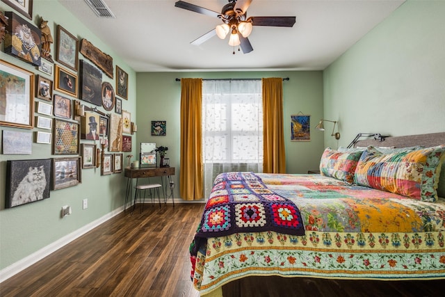 bedroom with ceiling fan, wood finished floors, visible vents, and baseboards