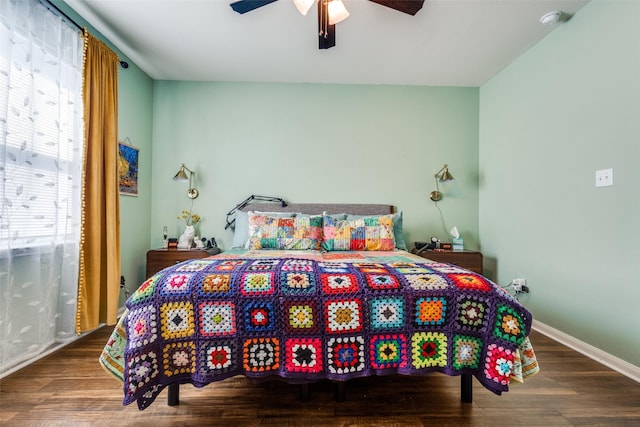 bedroom with a ceiling fan, baseboards, and wood finished floors