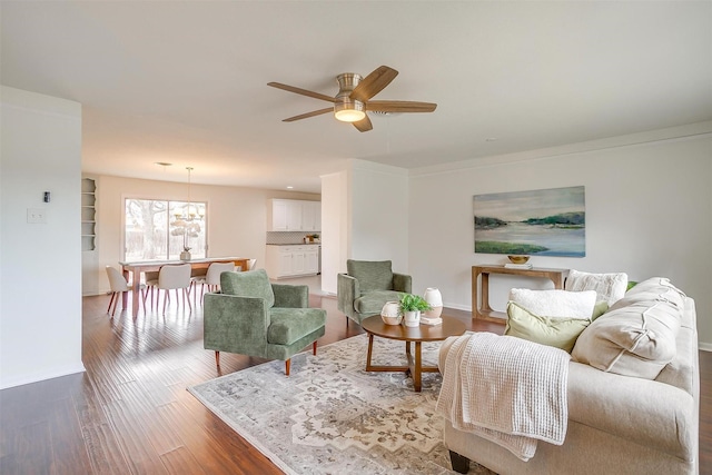 living area featuring wood finished floors, a ceiling fan, and baseboards