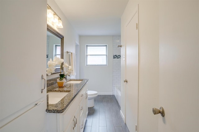 full bathroom featuring shower / tub combination, toilet, a sink, baseboards, and double vanity