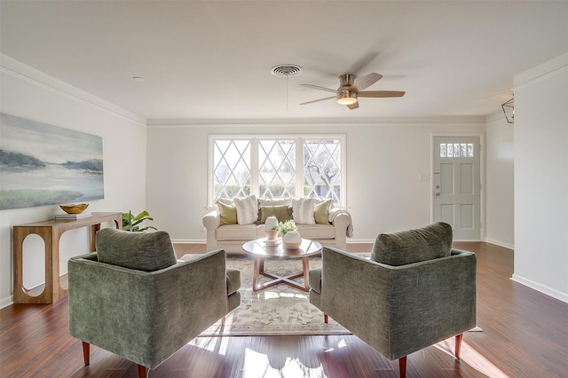 living area with crown molding, visible vents, dark wood-type flooring, a ceiling fan, and baseboards