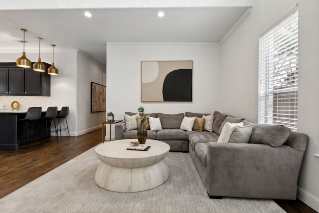 living area with baseboards, ornamental molding, wood finished floors, and recessed lighting