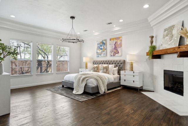 bedroom featuring baseboards, ornamental molding, dark wood-type flooring, a fireplace, and recessed lighting