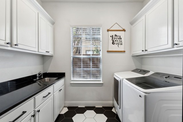 laundry area with cabinet space, baseboards, a sink, and washing machine and clothes dryer