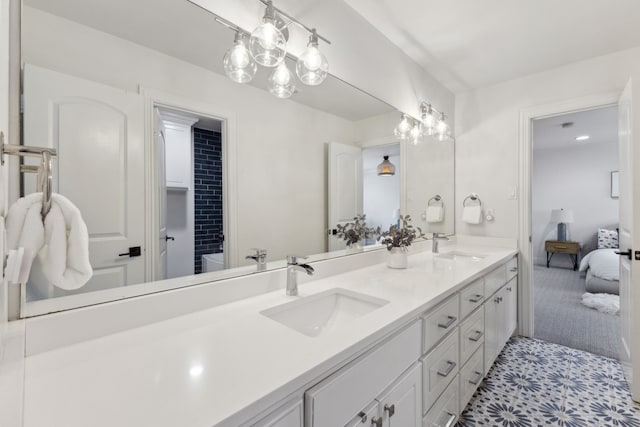 bathroom featuring double vanity, connected bathroom, and a sink