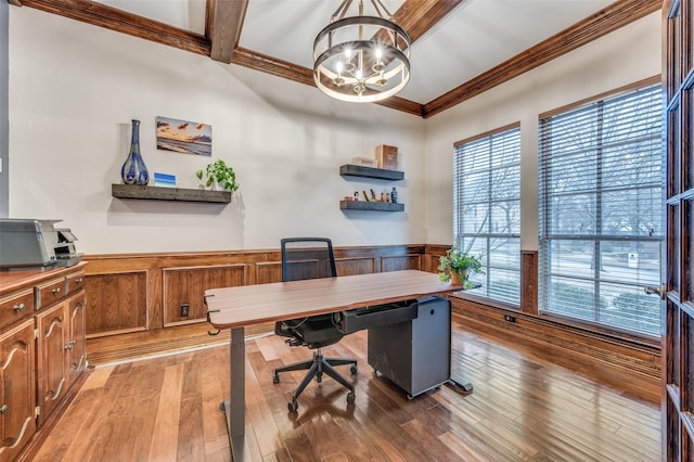 home office featuring a wainscoted wall, crown molding, light wood-type flooring, a chandelier, and beam ceiling