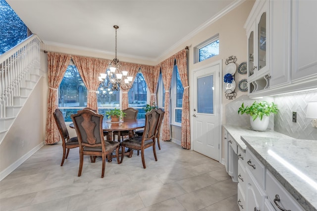 dining area featuring ornamental molding, stairs, baseboards, and an inviting chandelier