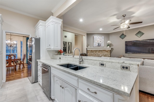 kitchen with crown molding, stainless steel appliances, open floor plan, a sink, and a peninsula