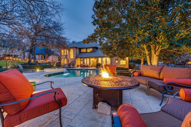 outdoor pool featuring a patio area and an outdoor living space with a fire pit