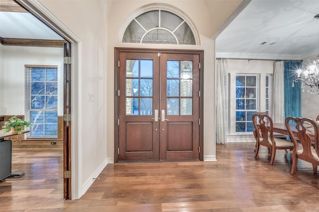 entryway featuring visible vents, ornamental molding, wood finished floors, and french doors