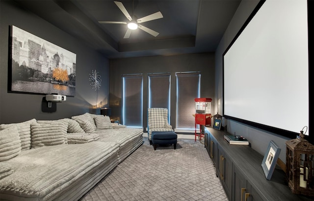 carpeted bedroom with ceiling fan and a tray ceiling