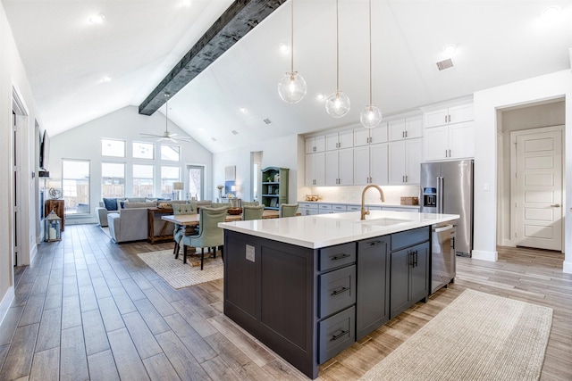 kitchen with stainless steel appliances, light countertops, visible vents, white cabinetry, and a sink