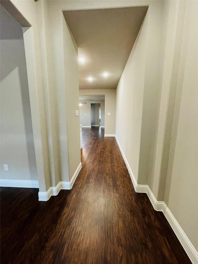 hall featuring dark wood finished floors and baseboards