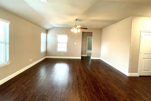 empty room featuring lofted ceiling, wood finished floors, a ceiling fan, and baseboards