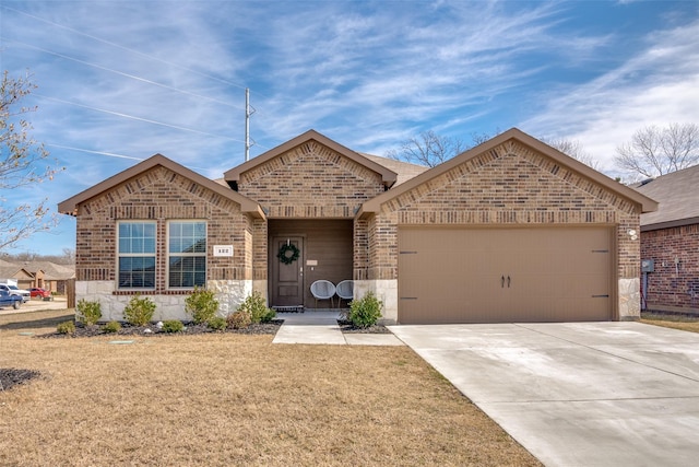 single story home with a front yard, brick siding, driveway, and an attached garage