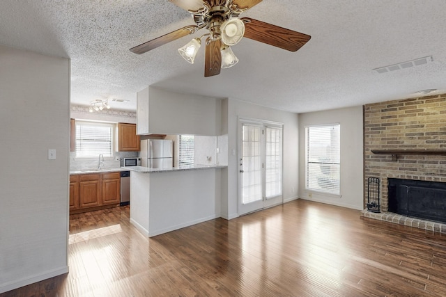 kitchen featuring stainless steel appliances, wood finished floors, a sink, and visible vents