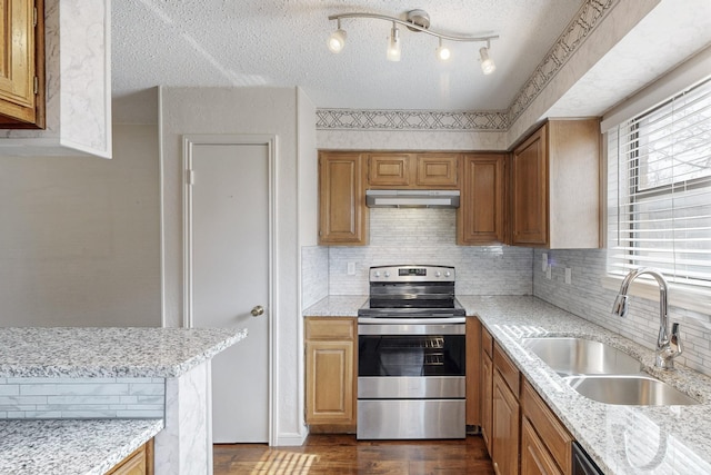 kitchen featuring a textured ceiling, under cabinet range hood, a sink, dark wood-style floors, and stainless steel range with electric stovetop