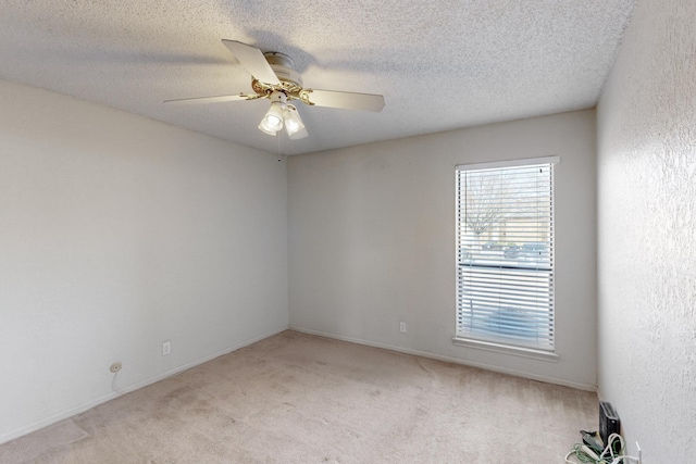 unfurnished room with light carpet, a textured ceiling, and a ceiling fan