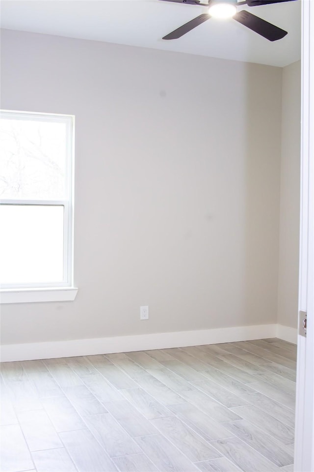 spare room with light wood-style floors, a ceiling fan, and baseboards