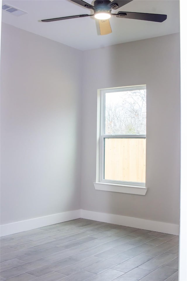 unfurnished room featuring baseboards, visible vents, and a ceiling fan