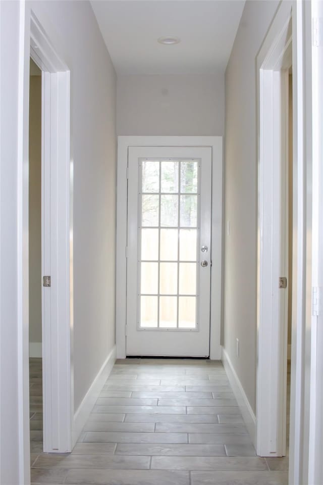 doorway to outside featuring light wood-type flooring and baseboards