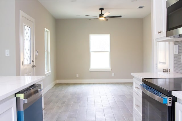 kitchen featuring stainless steel appliances, light countertops, visible vents, and white cabinets