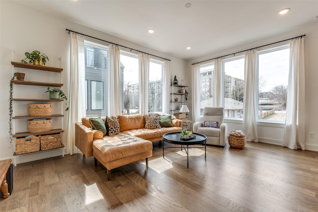 sitting room with baseboards, wood finished floors, and recessed lighting