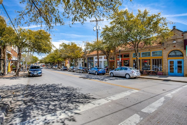 view of road with sidewalks, street lighting, and curbs