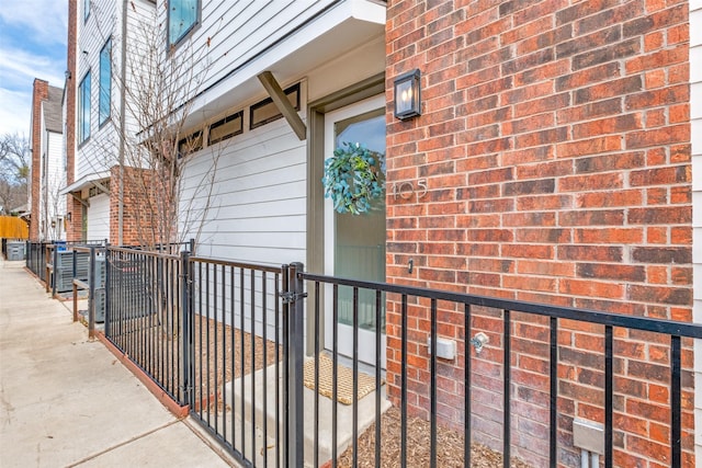 exterior space featuring a gate, brick siding, and fence