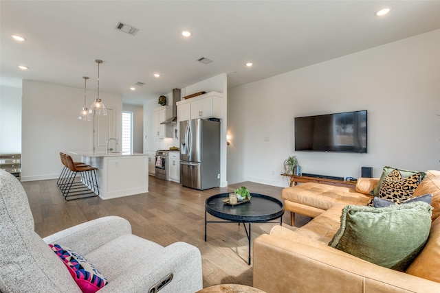 living area featuring visible vents, wood finished floors, and recessed lighting