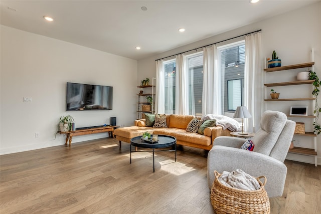 living room featuring baseboards, recessed lighting, and light wood-style floors