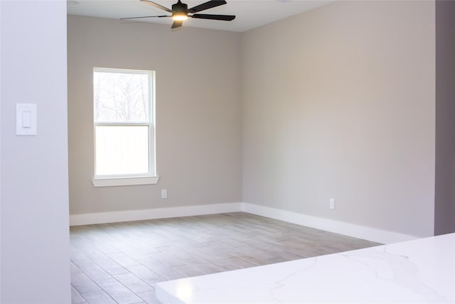 unfurnished room with light wood-type flooring, ceiling fan, and baseboards