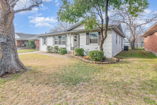 view of front of home with brick siding, a front lawn, central AC unit, and fence