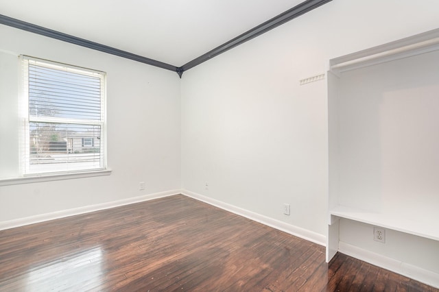 spare room featuring hardwood / wood-style floors, baseboards, and crown molding