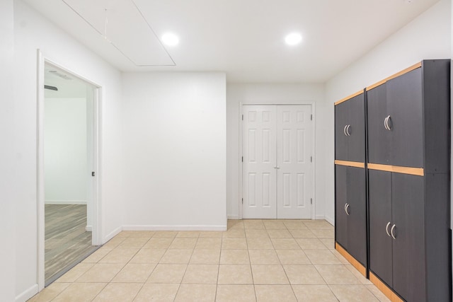 interior space with attic access, recessed lighting, baseboards, and light tile patterned floors