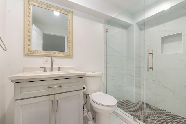 bathroom with toilet, a marble finish shower, and vanity