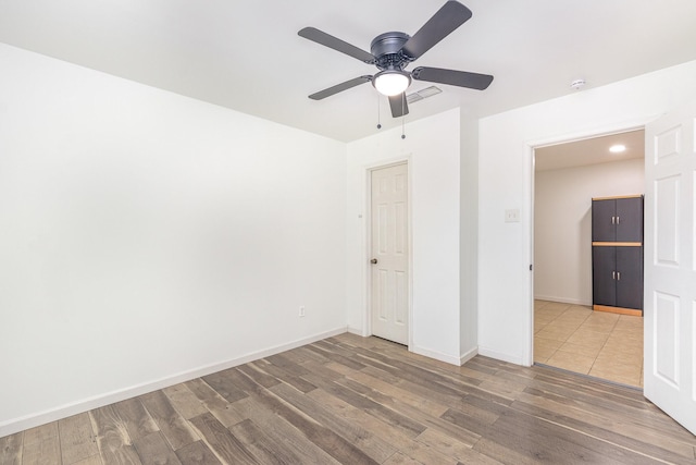 unfurnished bedroom featuring visible vents, baseboards, and wood finished floors