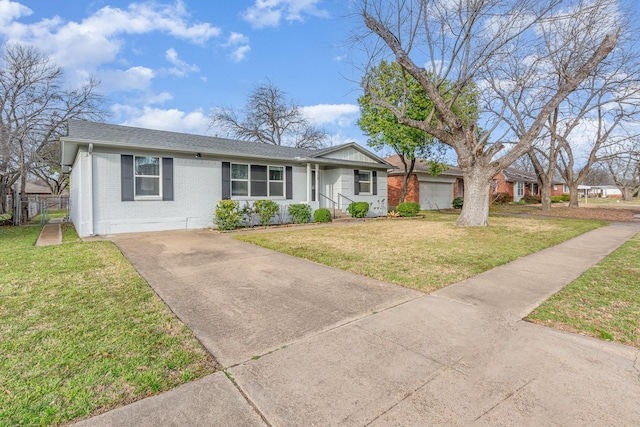 ranch-style home featuring roof with shingles, fence, a front lawn, and brick siding