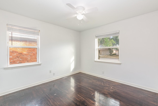 empty room with ceiling fan, wood finished floors, and baseboards