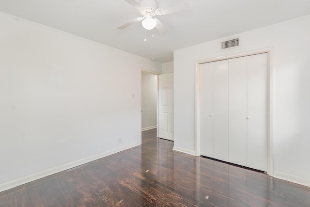 unfurnished bedroom with baseboards, visible vents, a ceiling fan, wood finished floors, and a closet