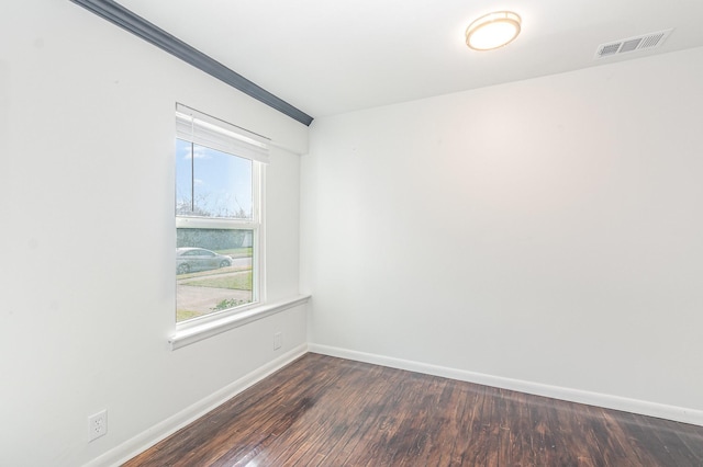 empty room with visible vents, baseboards, and wood finished floors