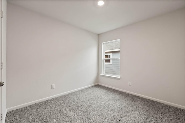 carpeted spare room with baseboards