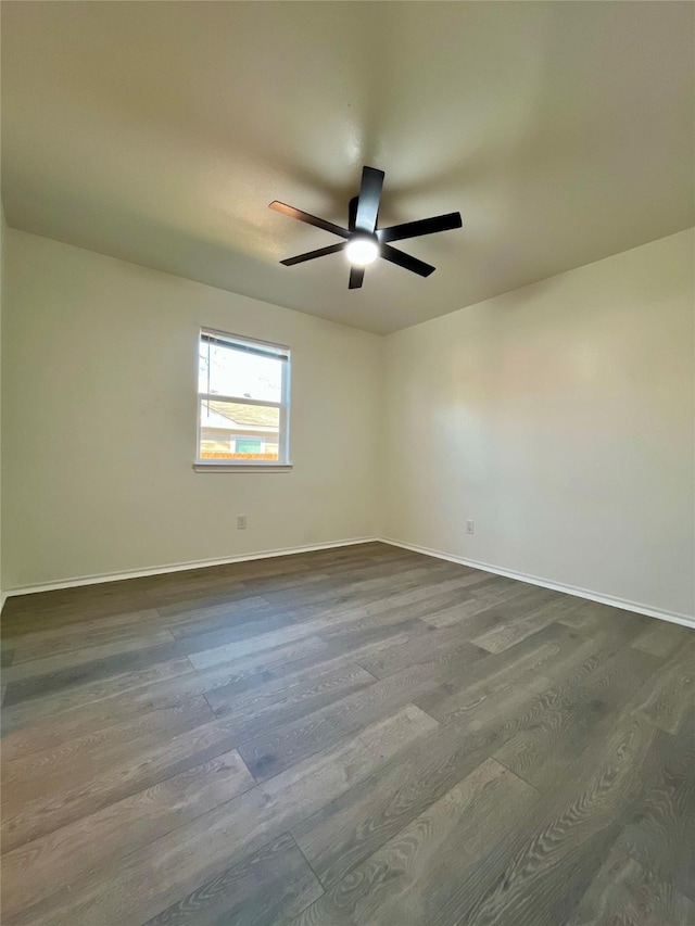 unfurnished room featuring ceiling fan, baseboards, and dark wood-type flooring