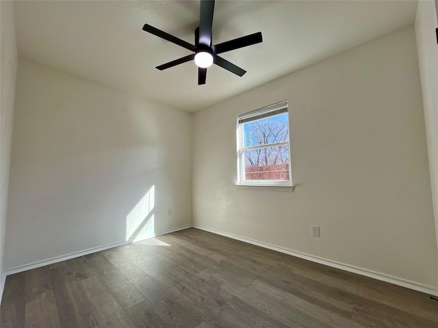 empty room with a ceiling fan, baseboards, and dark wood-style flooring