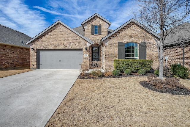 view of front of property featuring brick siding, driveway, and an attached garage