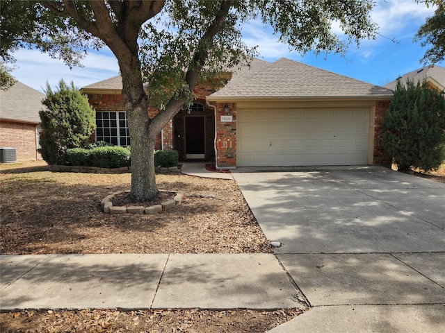 ranch-style home with a garage, concrete driveway, roof with shingles, central air condition unit, and brick siding