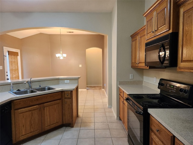 kitchen featuring black appliances, arched walkways, brown cabinets, and a sink