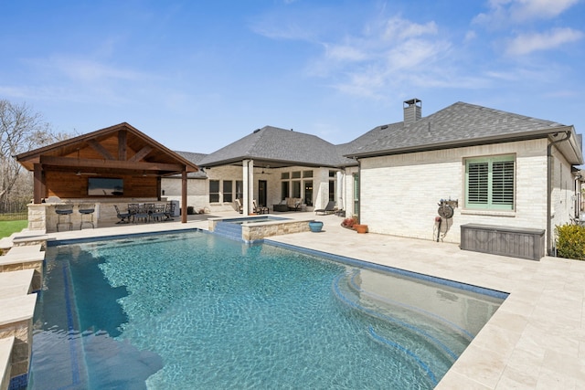 view of pool featuring outdoor dry bar, a gazebo, a patio area, and a ceiling fan