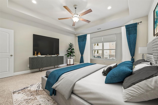 carpeted bedroom featuring recessed lighting, a raised ceiling, a ceiling fan, visible vents, and baseboards