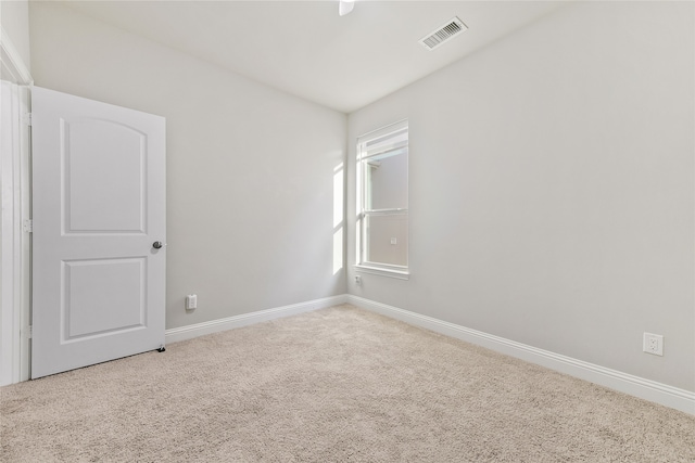 empty room with visible vents, carpet, and baseboards